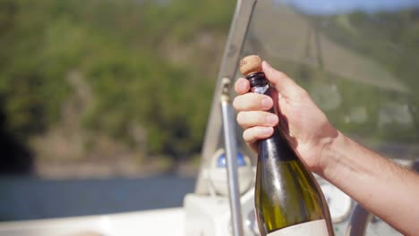 Abriendo-Una-Botella-De-Champán-En-Un-Bote,-Celebrando-Con-Amigos-En-Un-Lago-Tranquilo-En-Un-Día-De-Verano