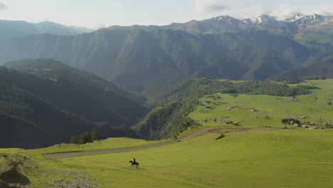 Weitschwenkende-Drohnenaufnahme-Eines-Mannes,-Der-Auf-Einem-Pferd-In-Upper-Omalo,-Tusheti-Georgia,-Reitet