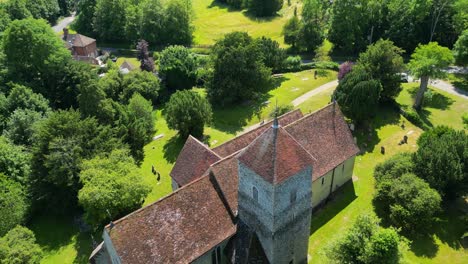 a tilted push-in shot flying over st lawrence the martyr church in godmersham