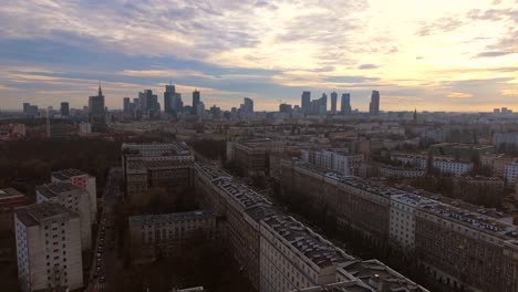drone ascending establishing over muranow district, revealing warsaw skyline and city center at sunset golden hour