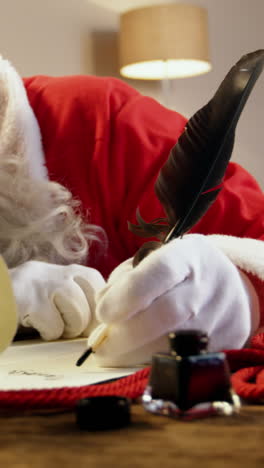 santa claus sleeping at desk while writing a letter with a quill