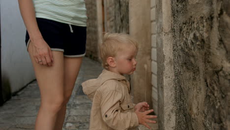 mother and toddler exploring a narrow alley