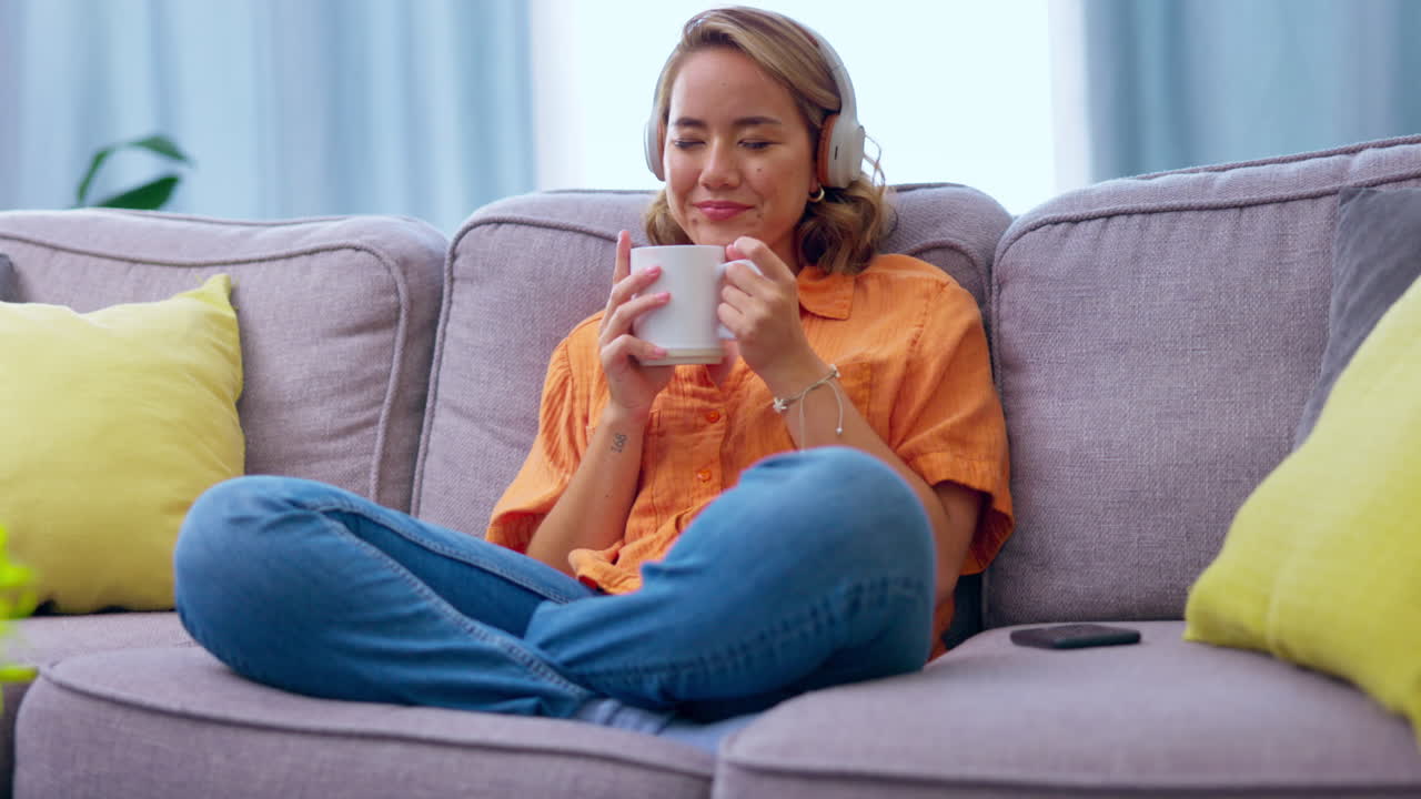 カウチでコーヒーを飲むアジア人女性