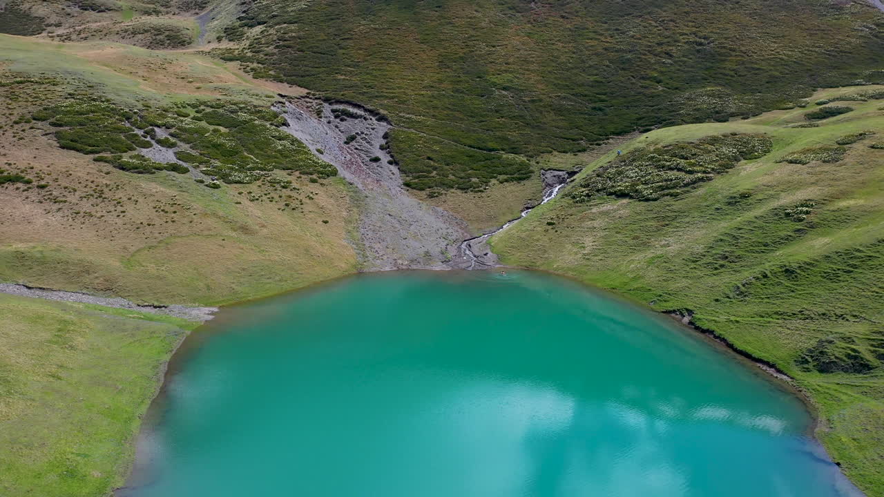 투셰티 조지아에 있는 오레티 호수의 푸른 바다에서 점프하는 사람의 드론 샷
