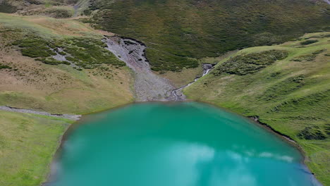 tiro de dron de una persona saltando en las aguas azules del lago oreti en tusheti georgia