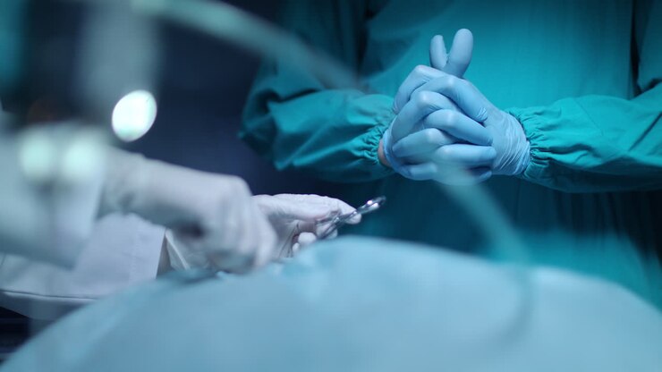 Surgeon hand working with surgeon tools. Medical operation. Surgeon sewing