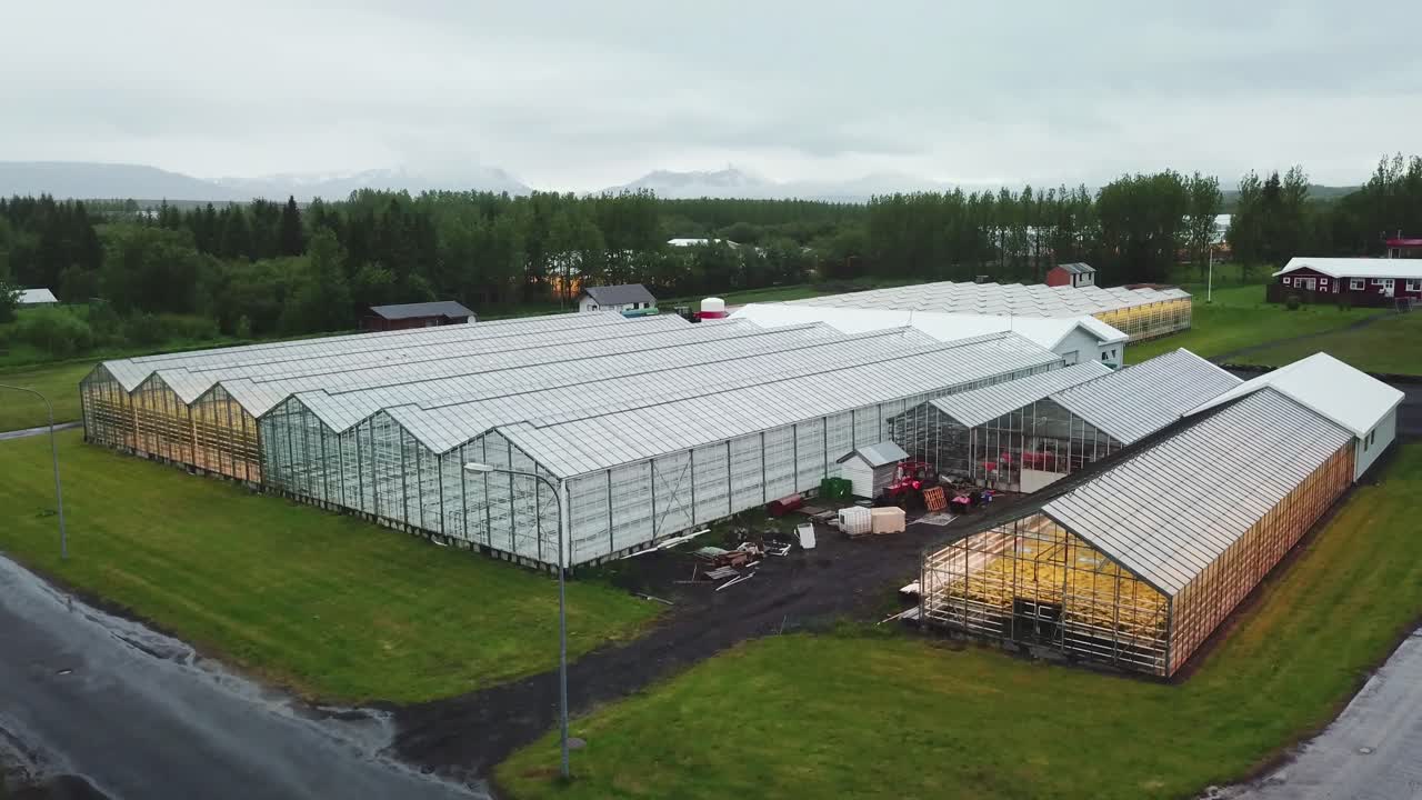 toma aérea de drones que establece una toma de un invernadero de islandia usando agua caliente geotérmica para cultivar frutas y verduras