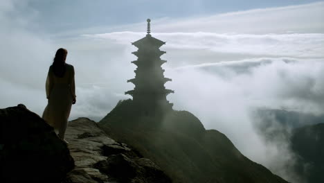 pagoda on a mountain with a woman in the foreground