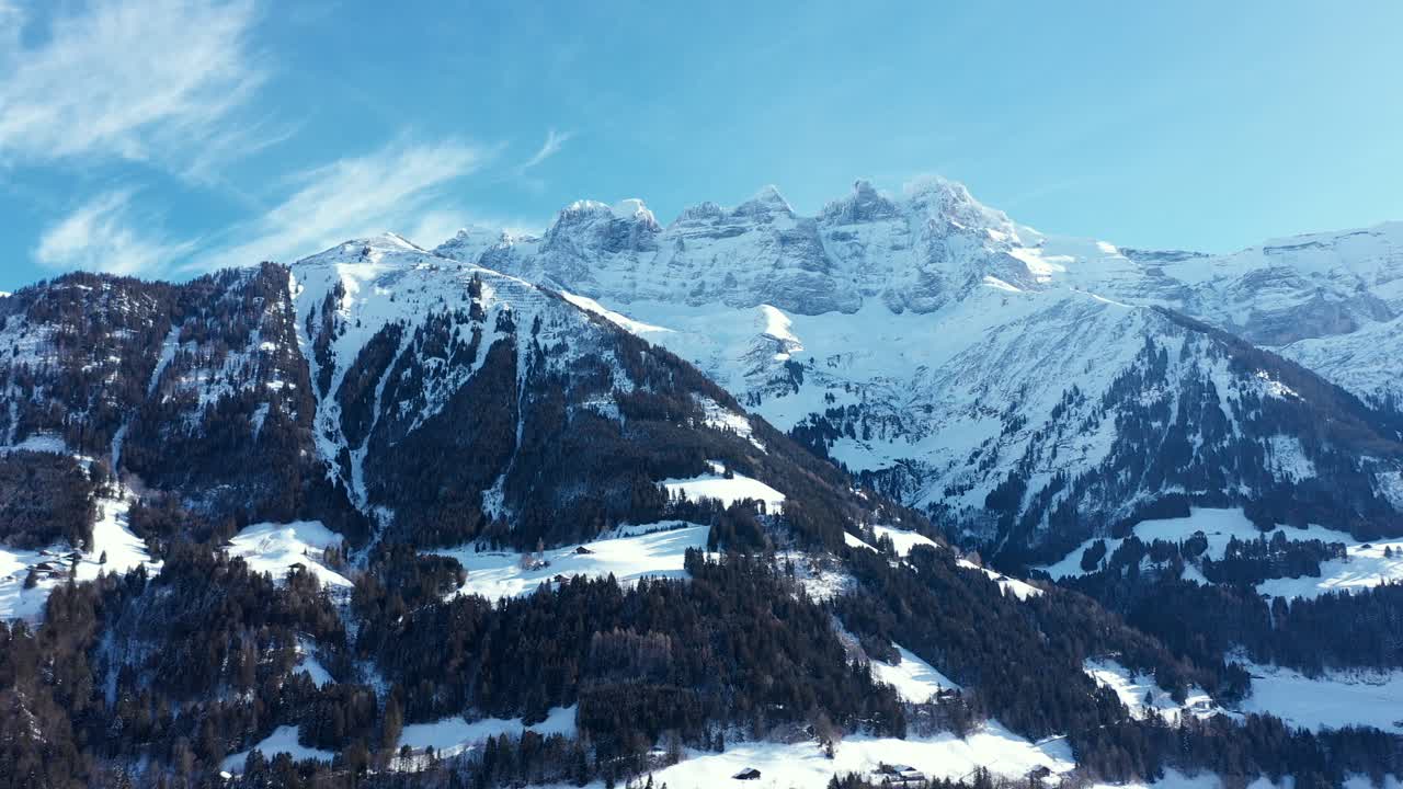increíble vuelo de drones de un impresionante valle alpino, pueblo y picos montañosos cubiertos de nieve en champery, suiza