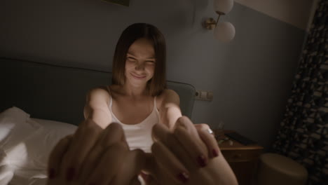 happy friends holding hands in bedroom