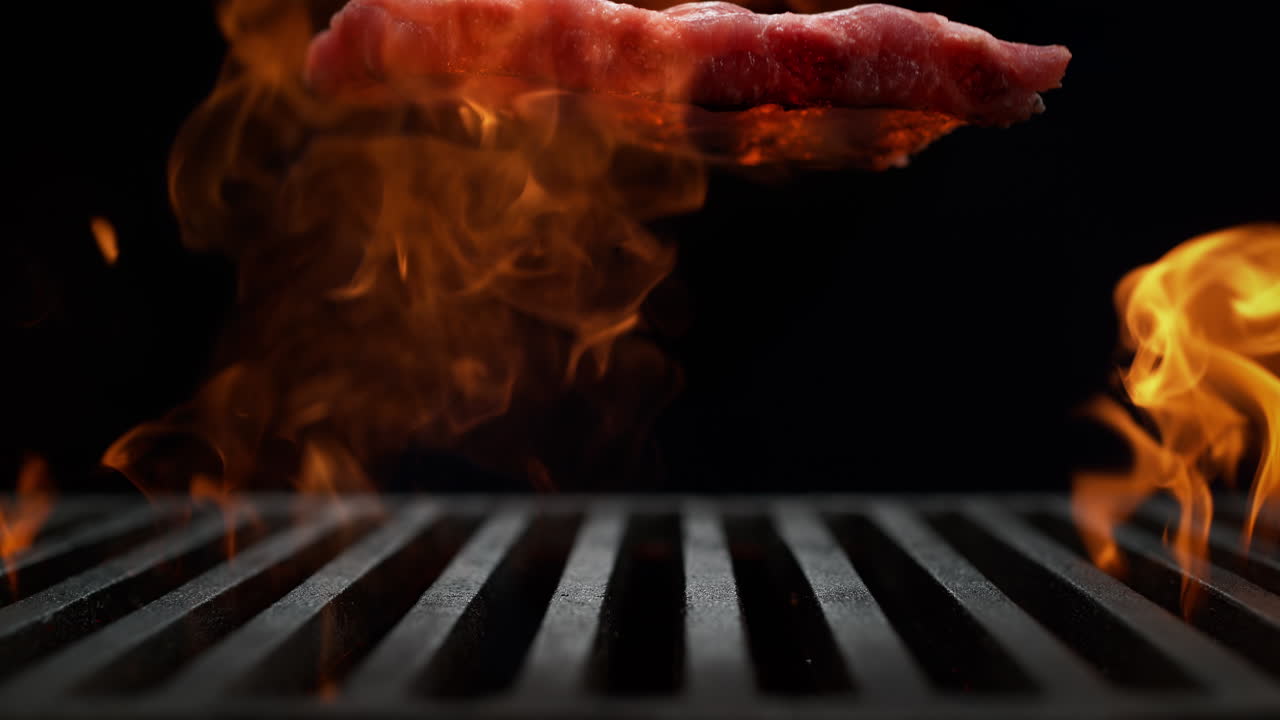 Raw Ribs Falling Onto The Grill Grate Flaming In Slow Motion, Summer BBQ Party on the Black Background