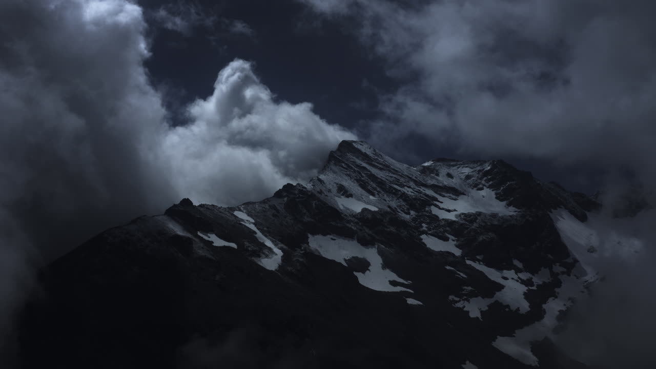 Night Clouds Over Snowy Mountain Peak