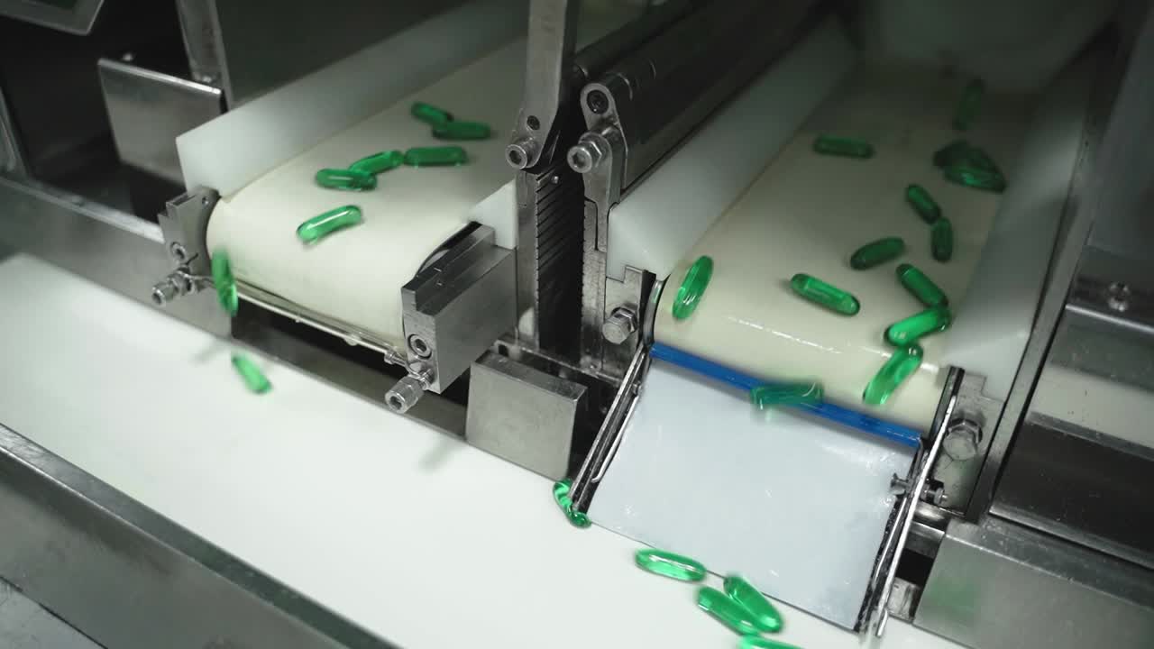 Automated sorting and redirecting green capsules on pharmaceutical conveyor system.