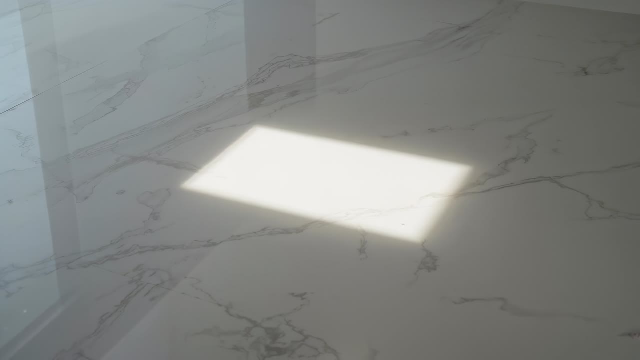 Raggio di sole in streaming che forma un rettangolo, che si sposta sul pavimento di marmo in una stanza vuota, ombra di montante