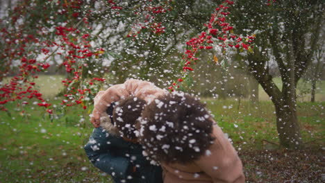 Two-children-having-fun-playing-in-snow-on-winter-walk-in-countryside---shot-in-slow-motion