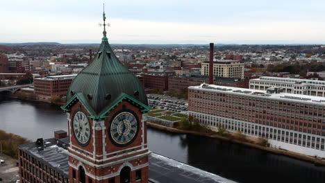 Ayer-Mill-Clock-Tower-En-Lawrence,-Massachusetts-Con-Vistas-Al-Río-Merrimack-Y-Al-Puente-Durante-El-Día---Primer-Plano-Aéreo,-Toma-En-órbita