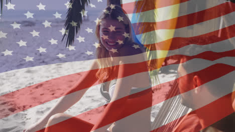 animation of american flag waving over couple in deckchairs laughing on beach