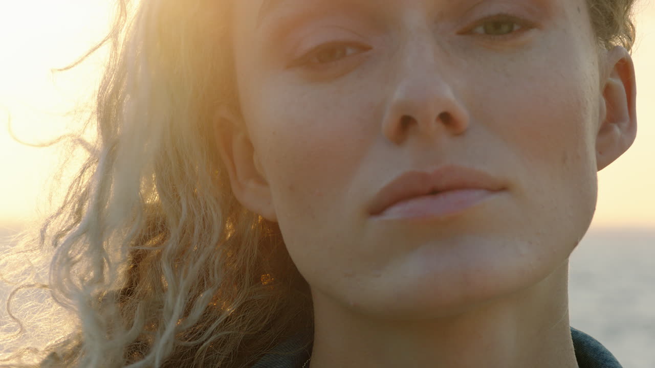 retrato en primer plano de una hermosa mujer rubia que parece segura disfrutando de un estilo de vida de vacaciones relajado sintiendo libertad en la orilla del mar al atardecer