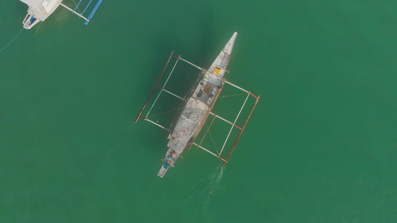 Flygfoto över Diapela Beach med fiskebåtar, hav och människor vid en livfull solnedgång i El Nido, Palawan, Filippinerna