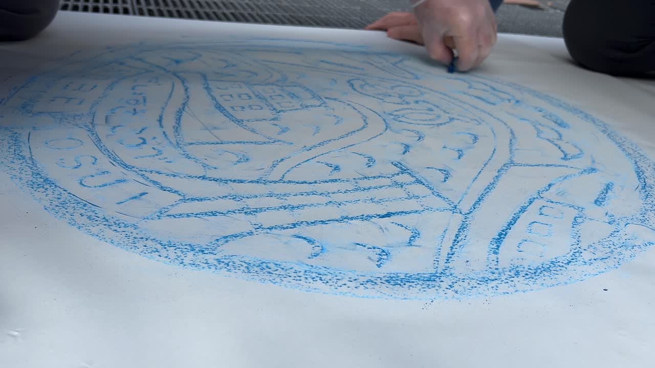 早回しタイムラプス：アーティストが炭で排水溝のふたの跡をたどる
