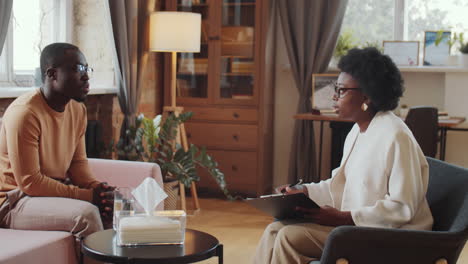 black man having therapy session with female psychologist
