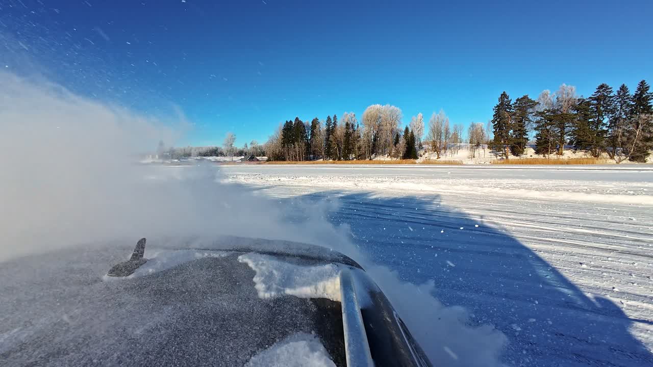 Hinterräder wirbeln funkelndes Pulver auf, eine am Auto montierte Kamera zeigt Drifting-Künste auf einem zugefrorenen See
