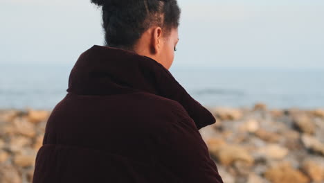 una chica afroamericana caminando por el mar.