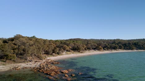 Felsen-Im-Meer-Am-Sandstrand-Mit-Dichter-Vegetation-Auf-Der-Halbinsel-Freycinet,-Tasmanien,-Australien