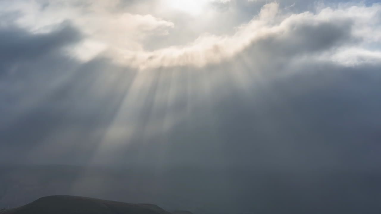 Dramatic Sun Rays Piercing Through Dark Clouds