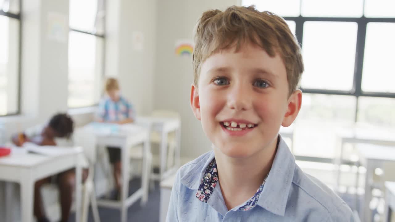 Video of happy caucasian boy standing in class during lessons
