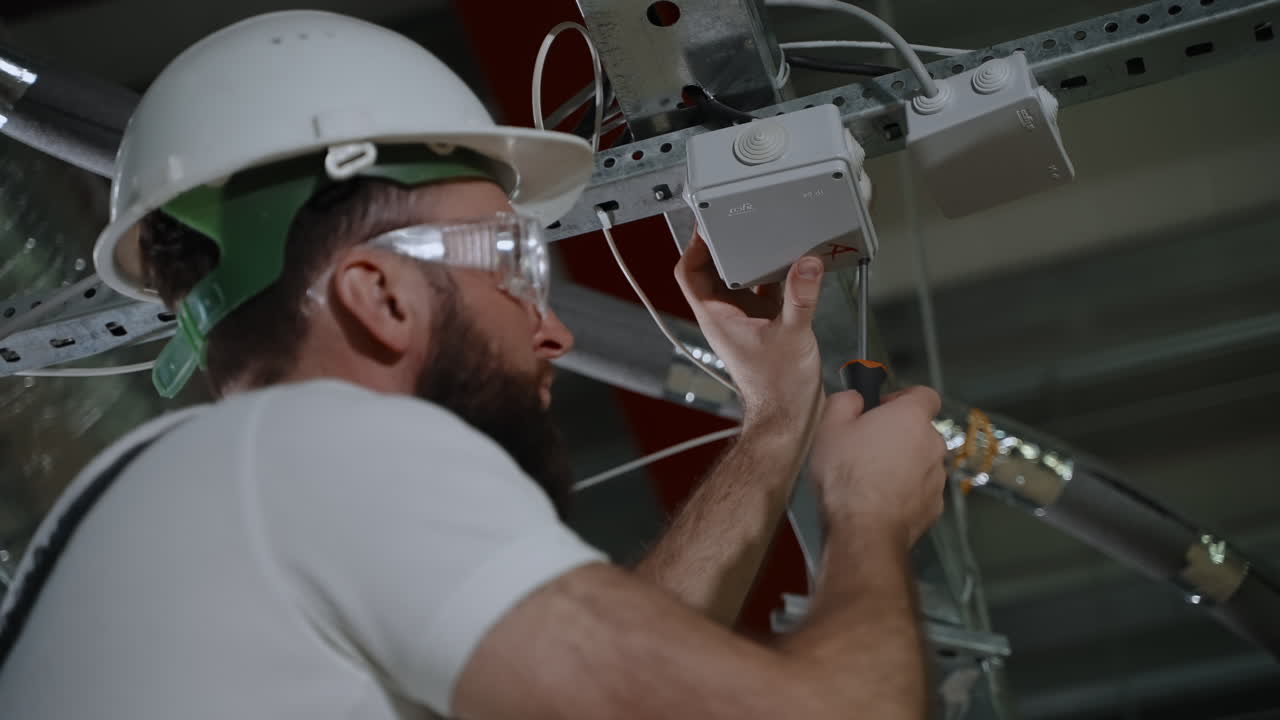 electricista que trabaja en la instalación de paneles eléctricos