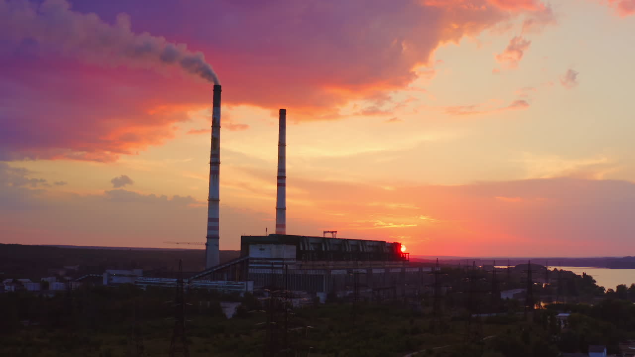 Harmful industry causes ecological problems. Dangerous smoke goes from chimney of manufacturing on the colorful sky background.