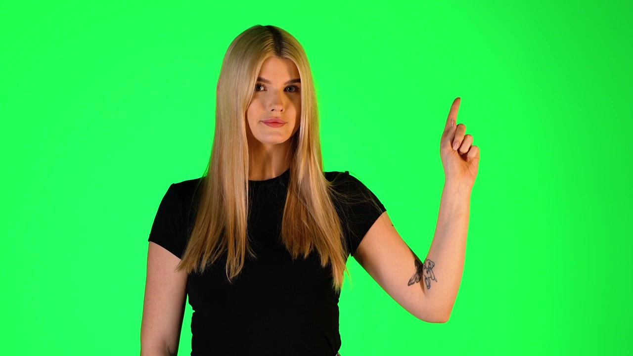 Pretty Young Blonde Woman Presenting and Pointing Up With Finger, Studio Green Background