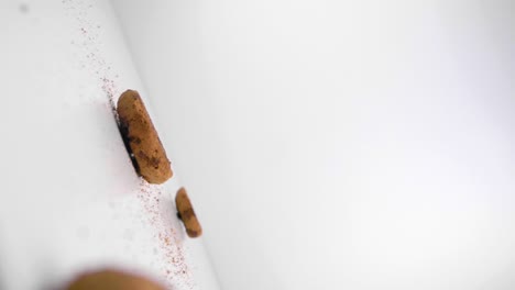 slow motion static shot of delicious vegan cookies with chocolate chunks falling