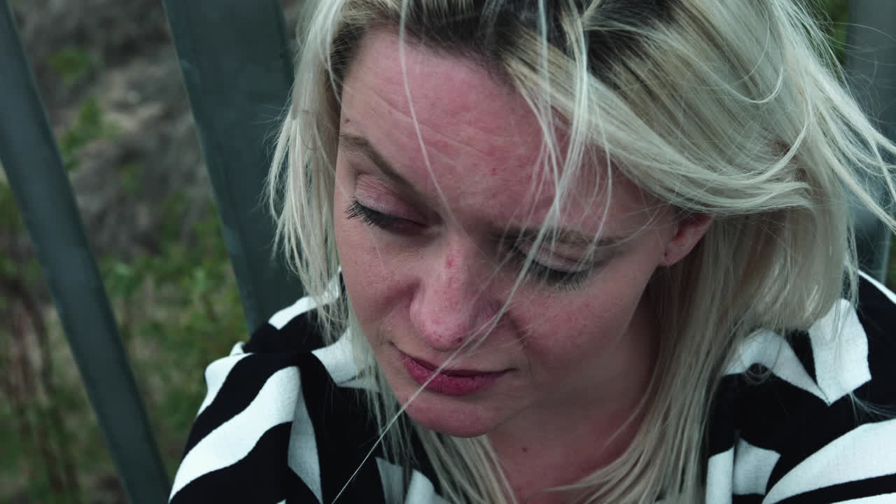 카메라를 바라보는 슬픈 금발 소녀의 클로즈업 샷, 슬로우 모션