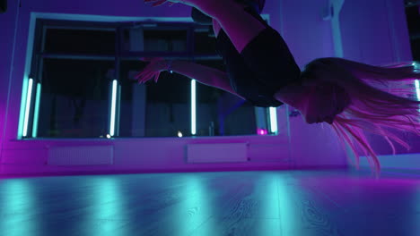 mujer colgada boca abajo y usando un columpio de hamaca de yoga mientras hace un ejercicio de yoga antigravedad. vista posterior de una hermosa joven usando una hamaca para hacer una postura de yoga antigravedad