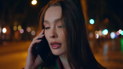 hermosa dama hablando teléfono inteligente de pie ciudad nocturna de cerca. mujer llamando