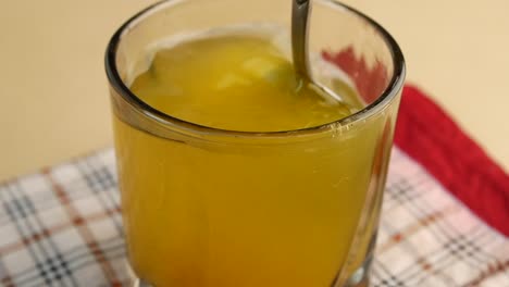 glass of yellow drink with spoon