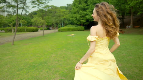 Pretty-woman-running-through-park,-looks-over-shoulder,-smiles