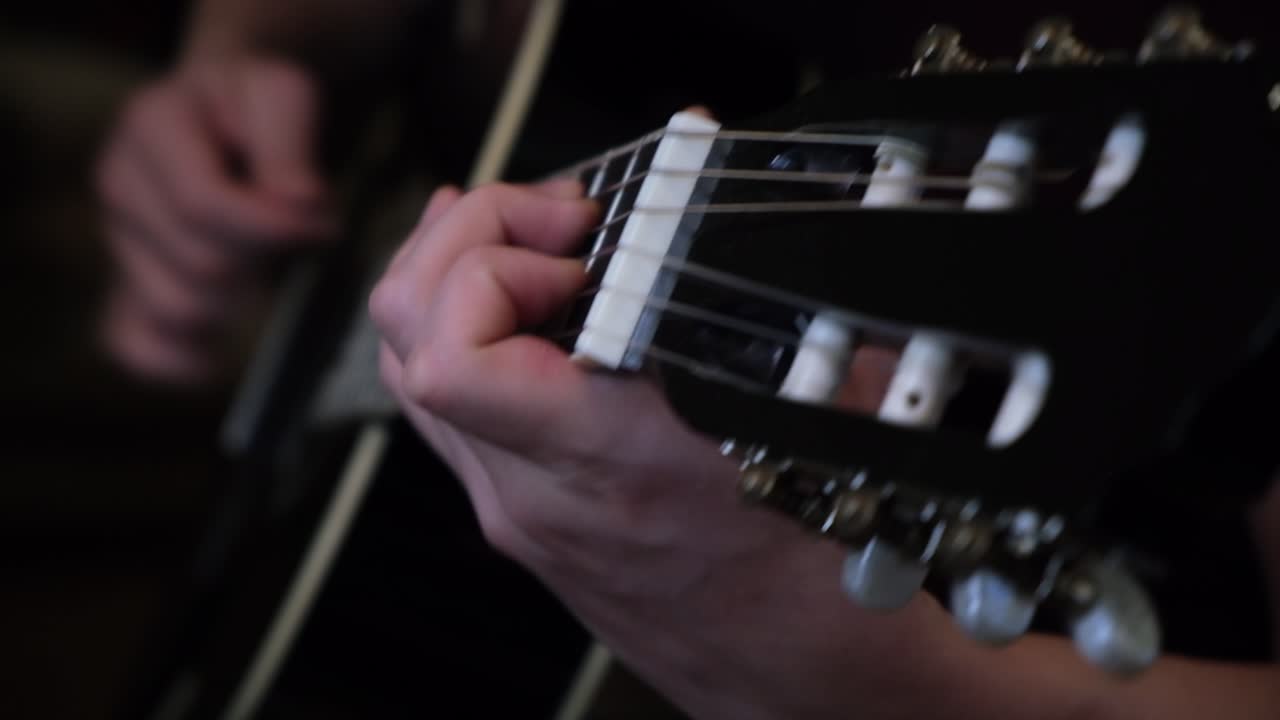 Close up of hands playing acoustic guitar