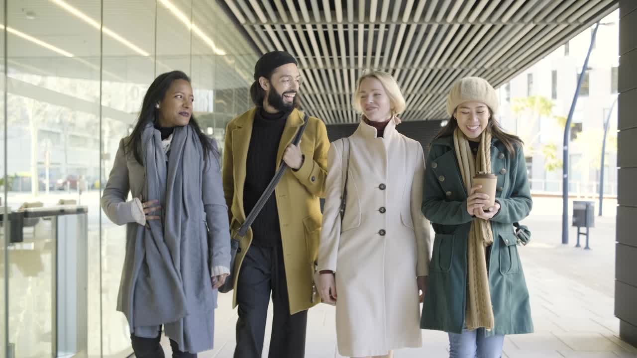 사무실 건물 밖 의 사업가 들 의 그룹 이 고 대화 하고 있다