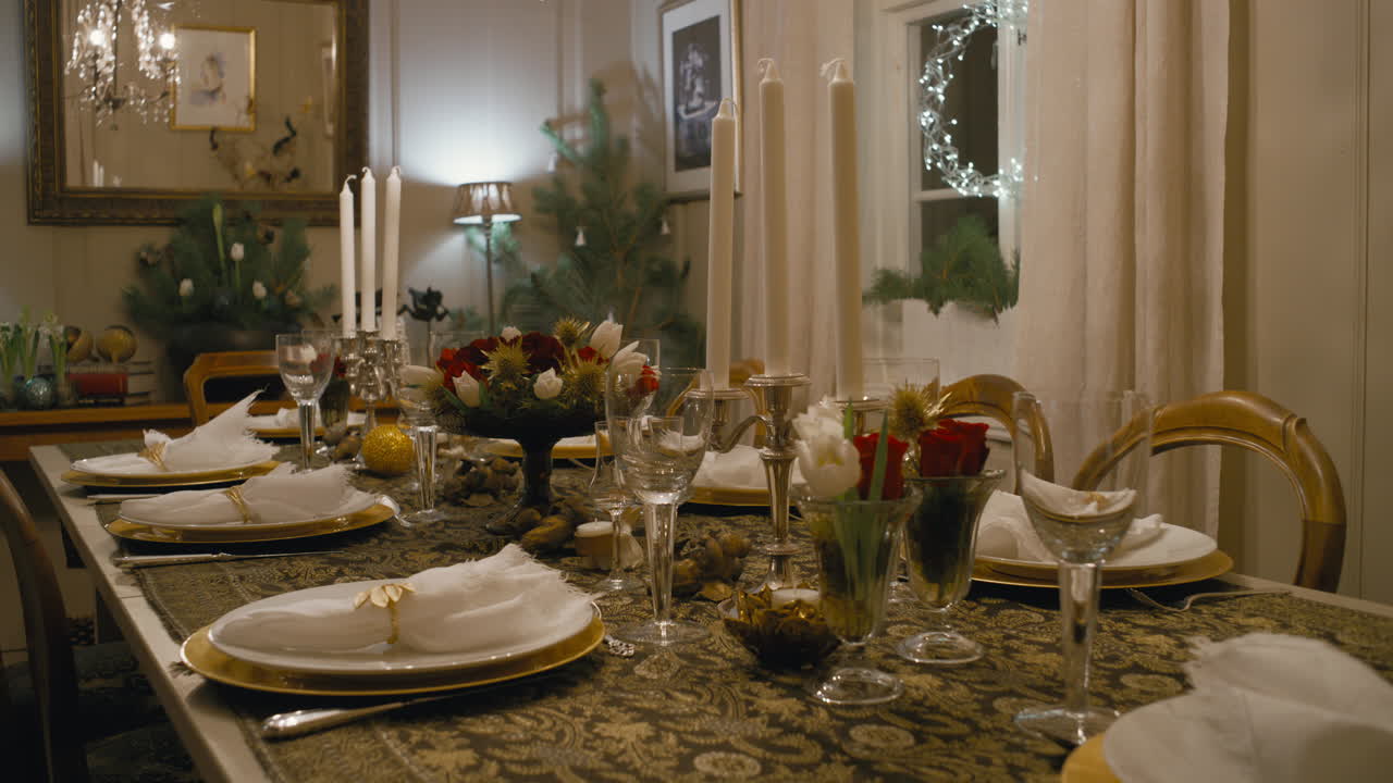 Set meja makan meriah untuk Natal, menampilkan lilin putih, detail emas, centerpiece bunga, dan pencahayaan sekitar yang hangat