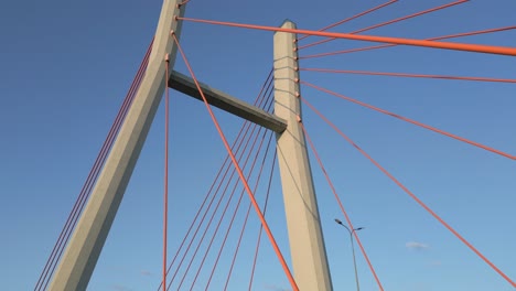 Ascending-towards-the-sky,-the-steel-cables-and-pylons-bask-in-the-warm-glow-of-the-setting-sun