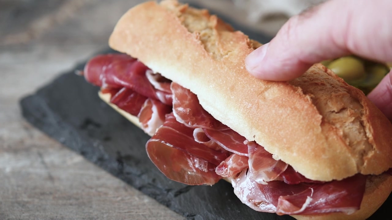 Panino con prosciutto serrano spagnolo su tavolo di legno. Bocadillo de jamón serrano spagnolo