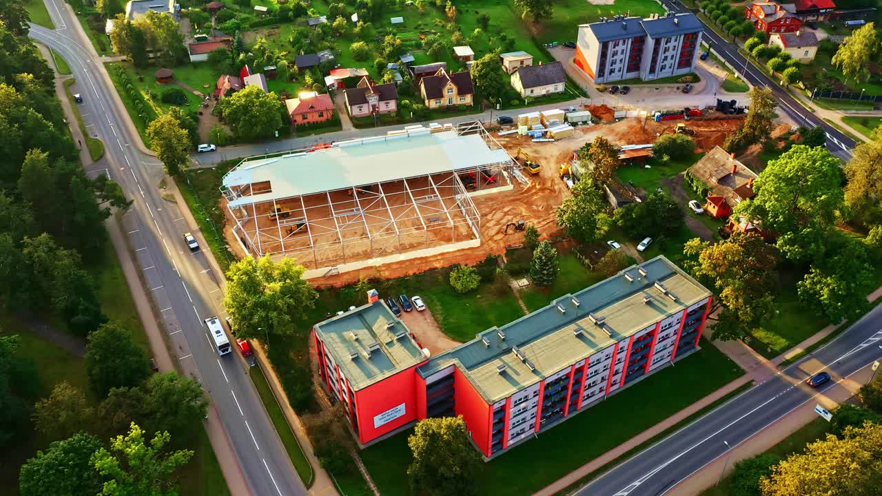 Cantiere di un negozio al dettaglio a Smiltene, Lettonia, con edifici residenziali e strada