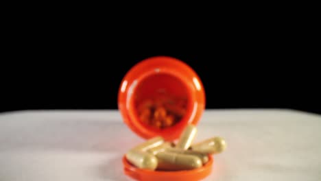 pulling past opening of a orange supplement pill bottle, revealing bottle's cap