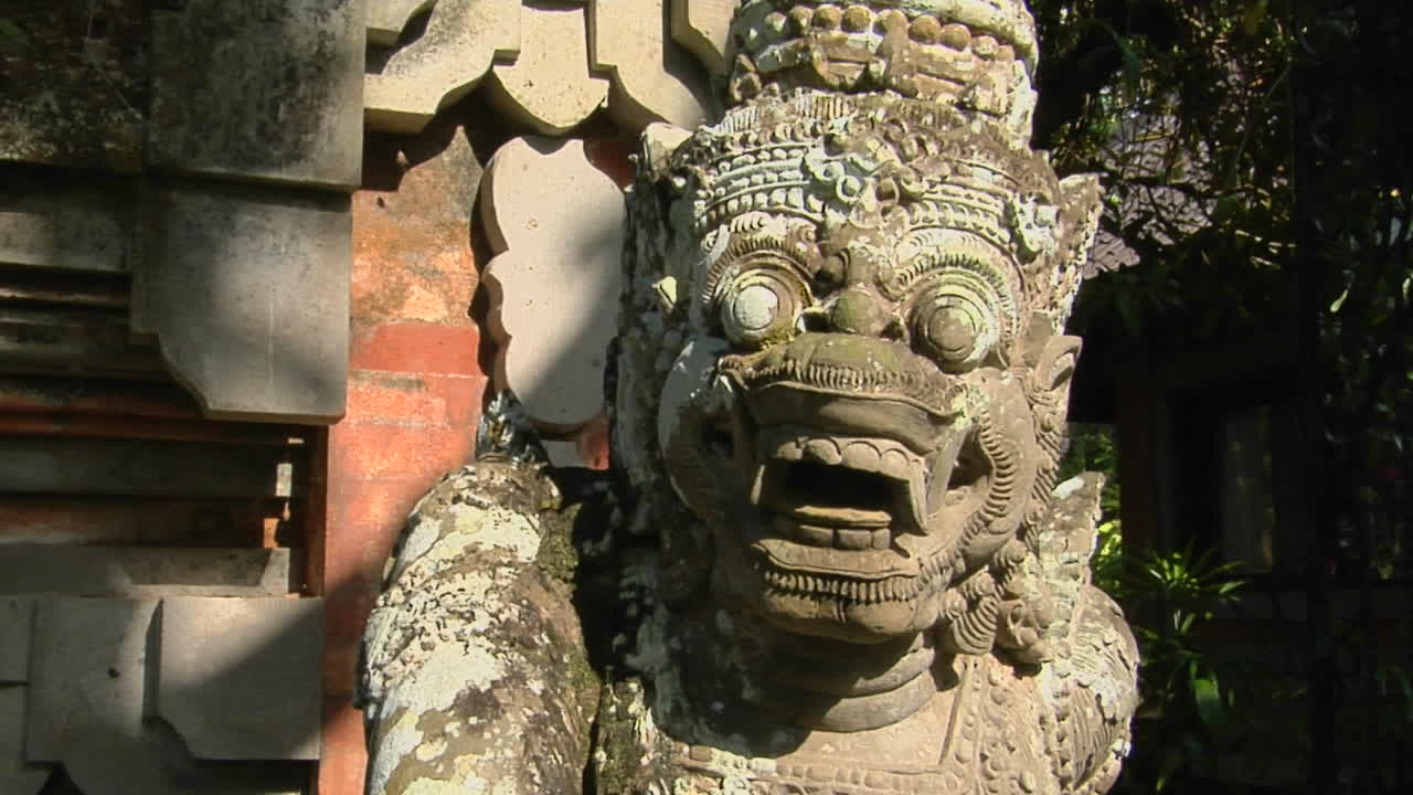 발리 신의 돌 조각이 사원을 지키고 있습니다.