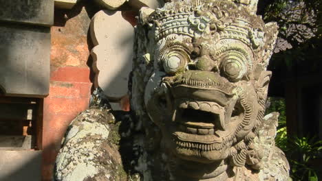 a balinese god stone carving guards a temple