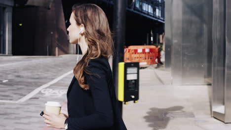 attractive business woman commuter using smartphone walking in city of london