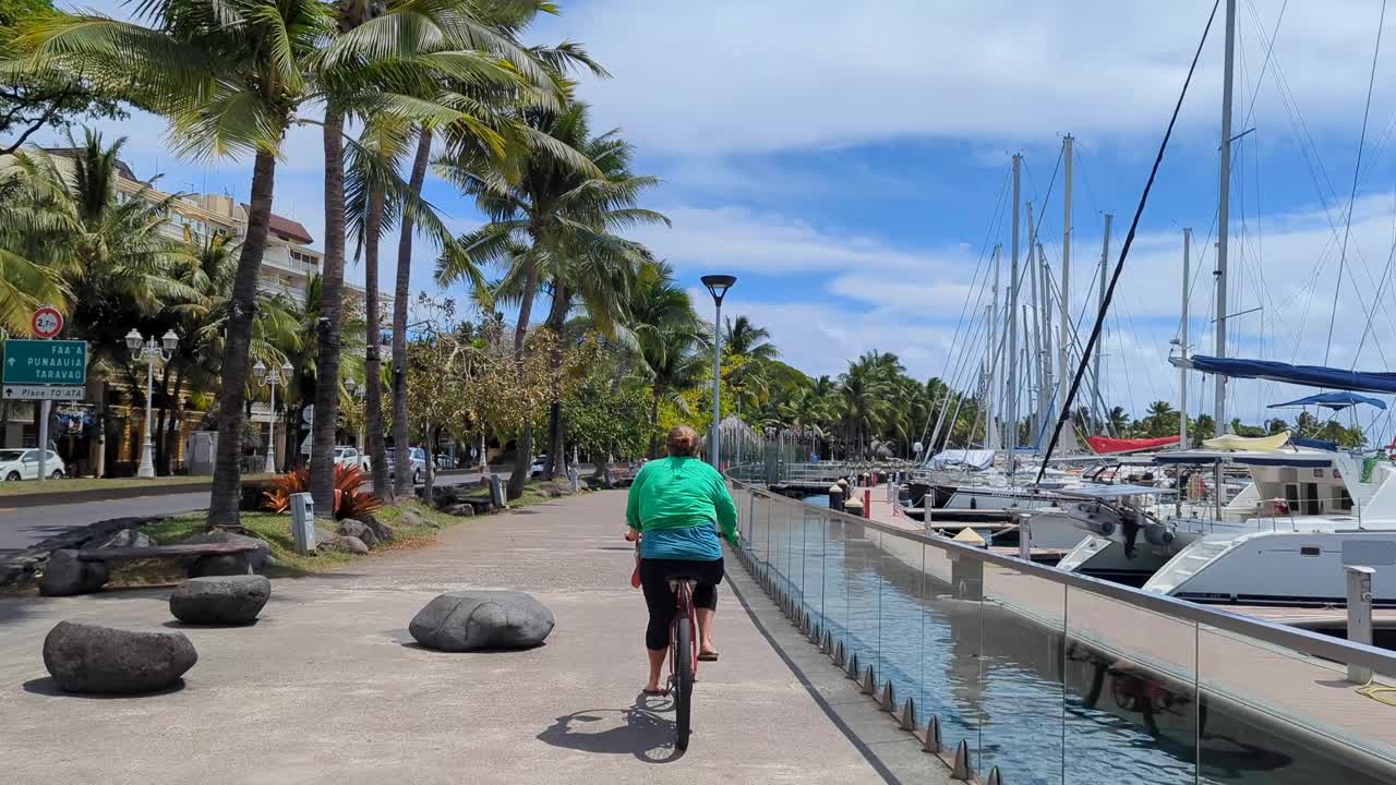 Woman Cycling Along a Scenic Path by the Marina